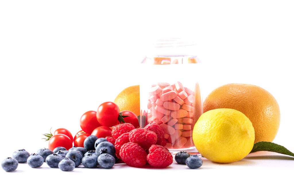 A beautiful shot of fresh fruits, berries with medical pills in a transparent jar 